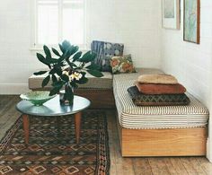 a living room filled with furniture and a plant in a vase on top of a table