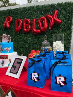 a table topped with blue bags and red balloons