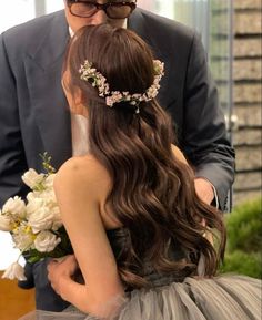 a man in a suit and tie is kissing a woman with long dark brown hair