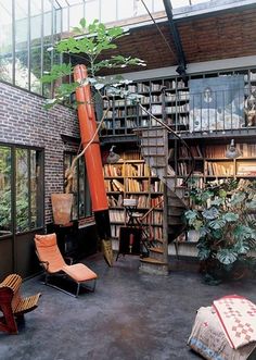 a room filled with lots of books and furniture next to a tall book shelf full of books