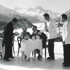 a group of men standing around a table in the snow