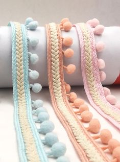 several different types of bracelets on a white surface with pink, blue and yellow beads