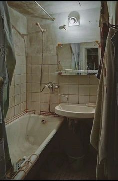 a bath tub sitting next to a sink under a mirror