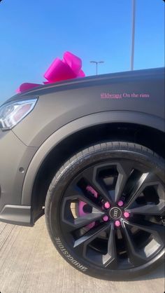 the front wheel of a car with pink bows on it