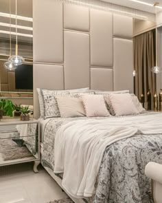 a bedroom with a large bed and mirrored nightstands on either side of the bed