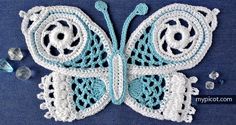 a crocheted blue and white butterfly with beads on it's back end