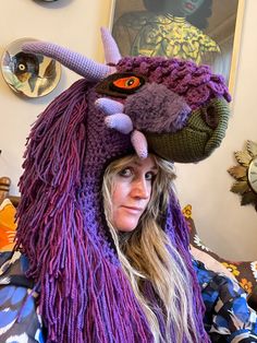 a woman wearing a knitted hat with an animal's head on top of it