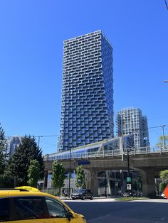 a yellow taxi driving down a street next to tall buildings