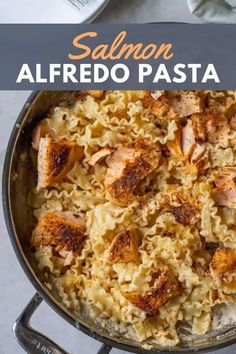 salmon alfredo pasta in a skillet with text overlay