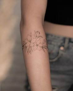 a woman's arm with a flower tattoo on the left side of her arm