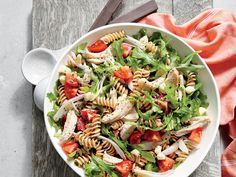 a salad with strawberries, carrots and lettuce on a white plate