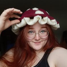 a woman wearing glasses and a crocheted hat