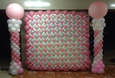 balloon decorations and balloons are arranged on the floor in front of a wall with an arch