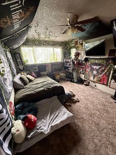 a messy bedroom with lots of clutter on the bed and ceiling fans in it