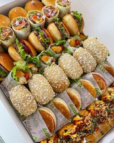 a box filled with lots of different types of sandwiches on top of eachother