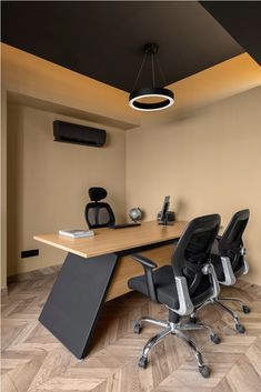 an office with two black chairs and a wooden desk in the center, along with a speaker system on the wall