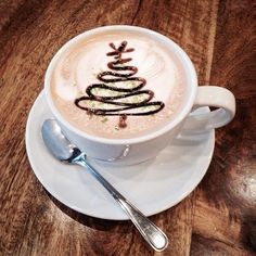 a cup of coffee with a christmas tree drawn on it