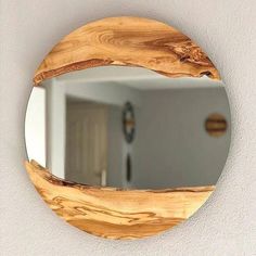 a round wooden mirror hanging on the wall