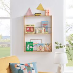 a living room filled with furniture and a book shelf on top of a window sill