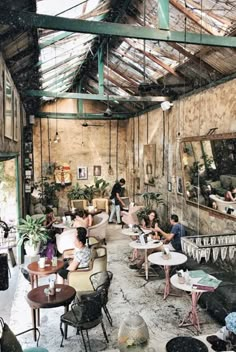 people are sitting at tables in an old building