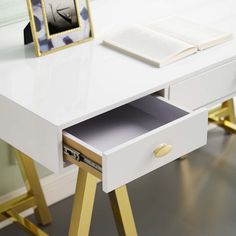 a white desk with gold legs and a book