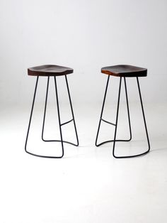 "This is a pair of vintage hairpin leg stools. Dynamic metal legs with curving design and wood saddle seats make these a fantastic pair of stools for the bar or kitchen counter. CONDITION In good condition with wear consistent with age and use. Slight variance in tone to the wood seats. MEASUREMENTS Height: 29\" .. 73.7 cm Width: 18\" .. 45.7 cm Depth: 15.5\" .. 39.4 cm Seat W x D: 16\" x 12\" .. 40.6 cm x 30.5 cm SHIPPING International and non-contiguous US customers, please contact us for ship Butterfly Candle Holder, Vintage Meets Modern, Vintage Clothing Online, Curve Design, Hairpin Legs, Small Light, Banquette, Kitchen Counter, The Bar