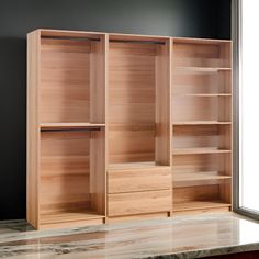 an empty wooden bookcase next to a window in a room with marble counter tops