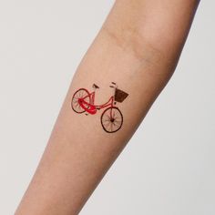 a red bicycle tattoo on the left arm