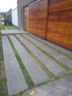 two wooden garage doors sitting next to each other on the side of a road with grass growing between them