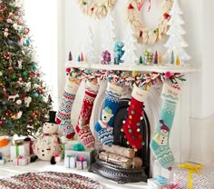 christmas stockings hanging from the mantle in front of a fireplace with presents and gifts around it