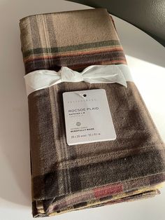 the folded plaid fabric has a tag on it