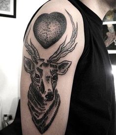 a man's arm with a deer and heart tattoo on the left upper arm