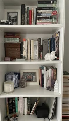 a white book shelf filled with lots of books