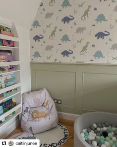 a child's room decorated with dinosaur wallpaper