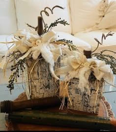 two white pumpkins decorated with bows sit on a table next to an old baseball bat