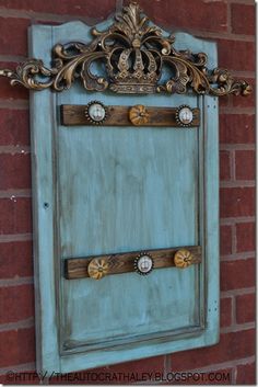 an old blue door on the side of a brick building with gold trimmings