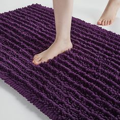 a person standing on top of a purple rug