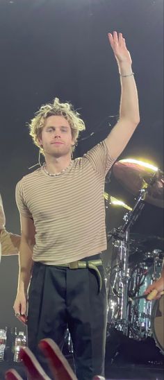 a man standing on stage with his arms in the air