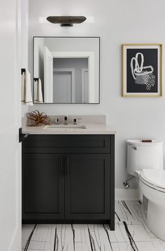 a bathroom with a sink, mirror and toilet in it's centerpieces