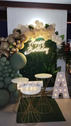 a birthday party with balloons and lights on the wall, chairs and tables in front of it