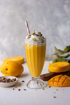 an orange smoothie with whipped cream and nuts on the side, surrounded by other fruits