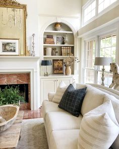 a living room filled with furniture and a fire place in front of a white fireplace