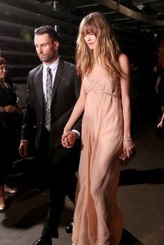 a man and woman in formal wear walking together