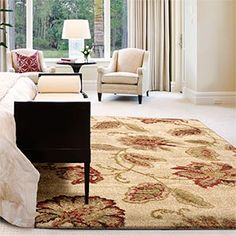 a living room filled with furniture and a large window covered in white drapes next to a bed