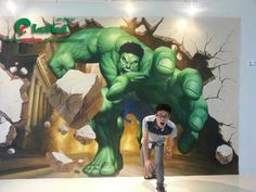 a man standing in front of a painting of a giant green hulk with his mouth open