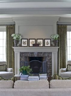 a living room filled with furniture and a fire place in front of a window covered in curtains