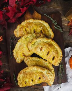 some food is laying out on a cutting board next to oranges and other autumn leaves