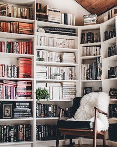 a chair in front of a book shelf filled with books