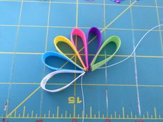 scissors are laid out on a cutting board to make paper flowers with the word love spelled in large letters