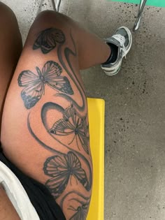 a woman's legs with butterfly tattoos on them